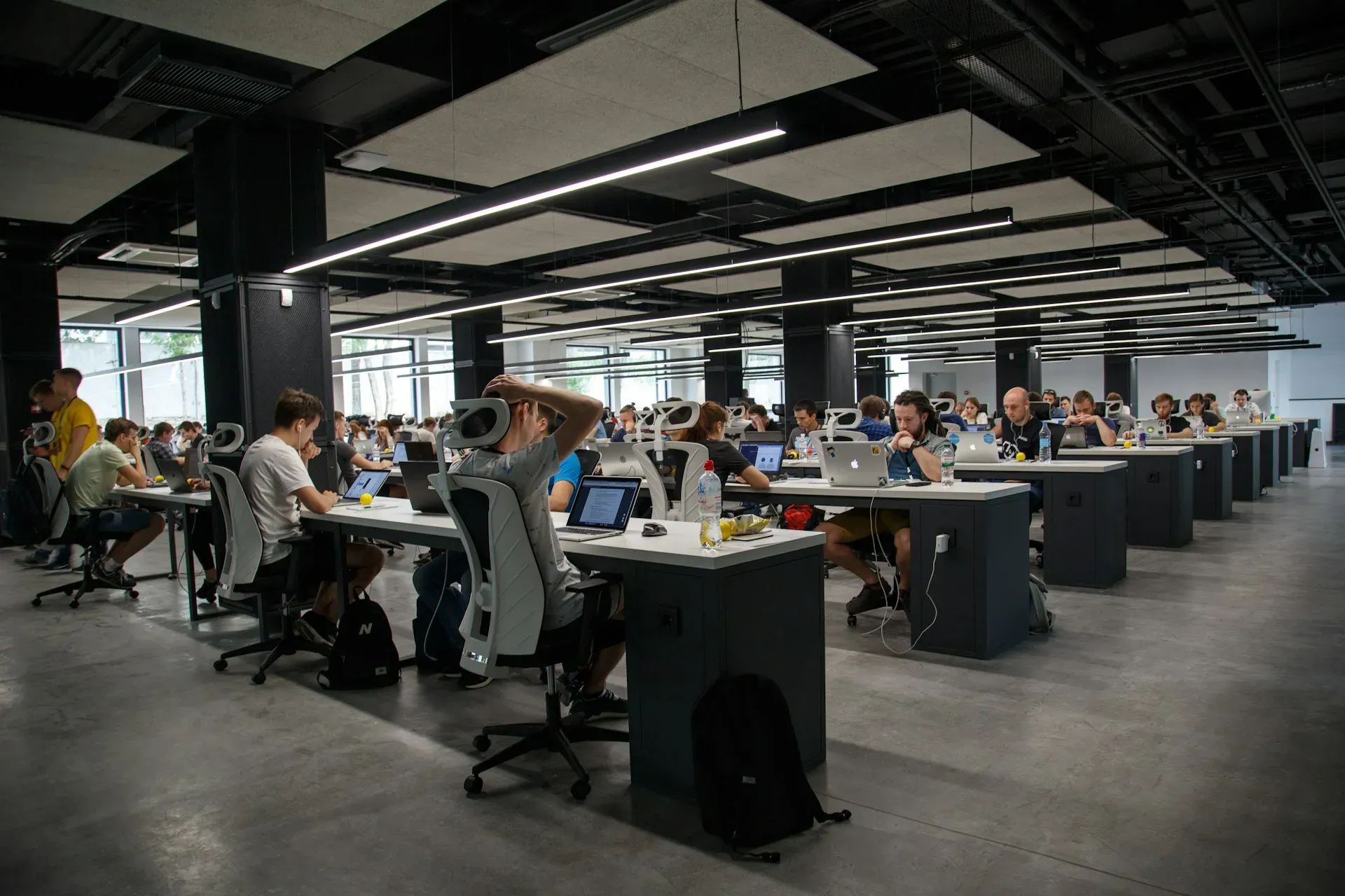 Open-plan technology office with teams working at laptops